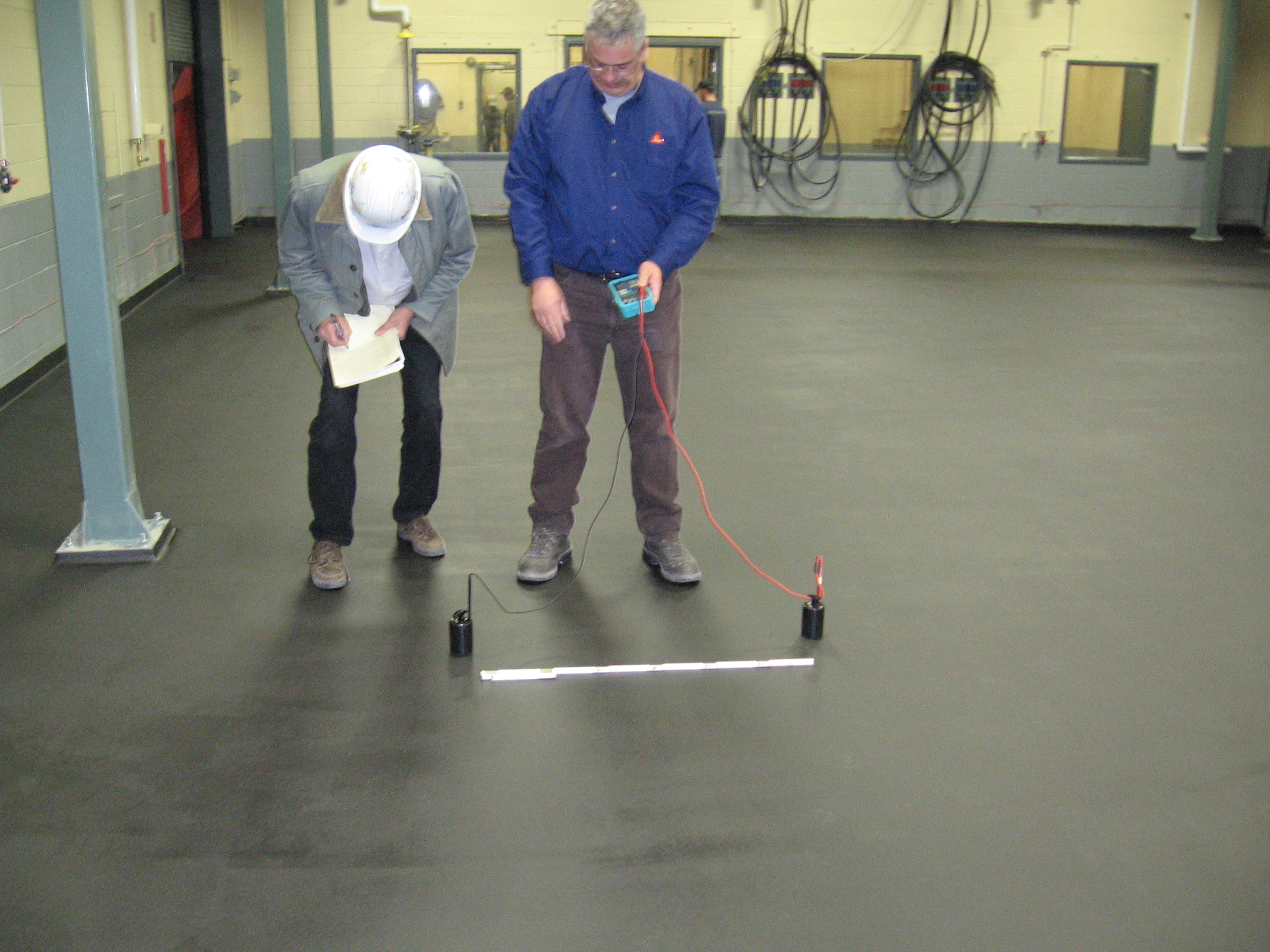 Technicians testing the electrical resistance of an anti-static floor