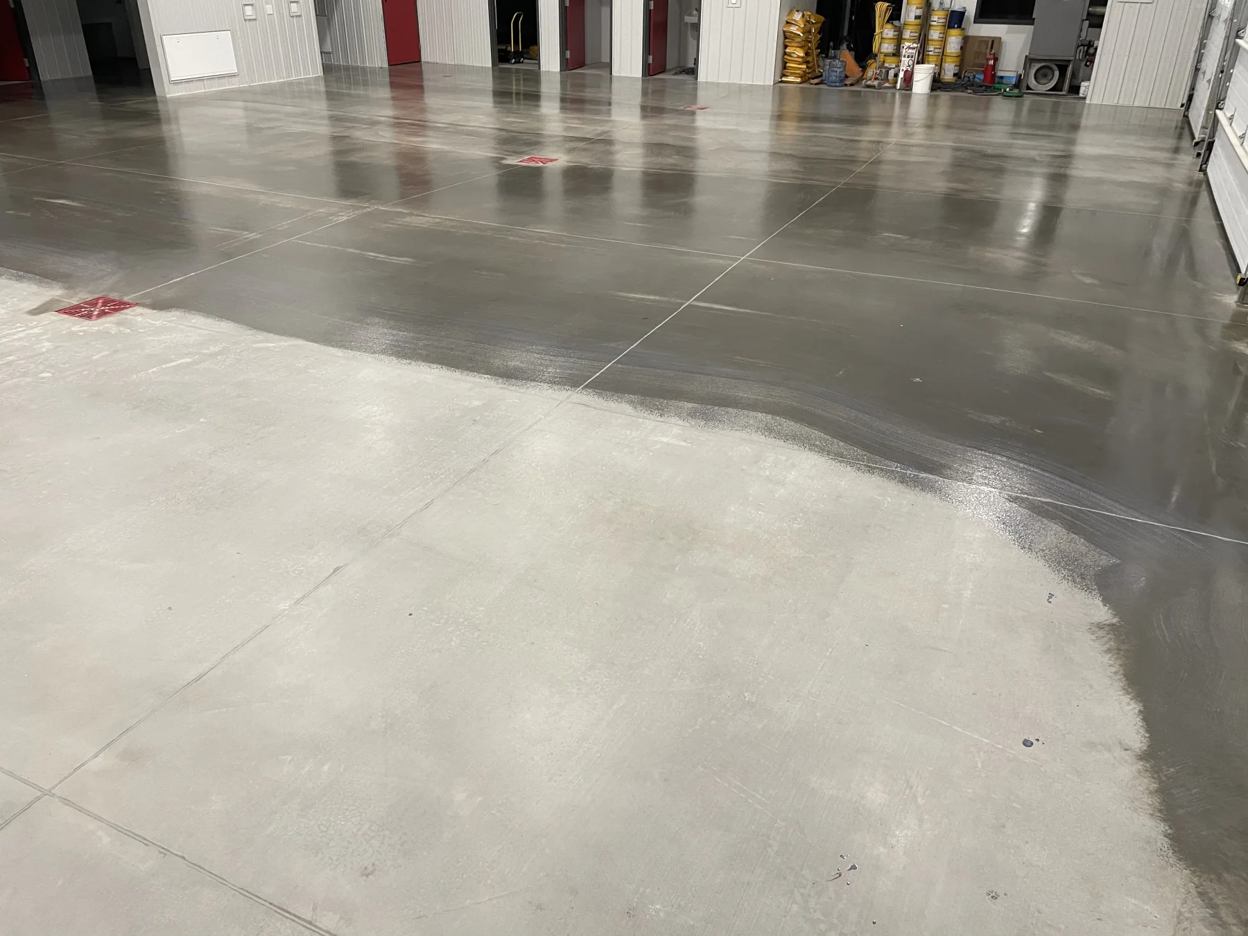 Concrete sealer application progressing across an industrial shop floor