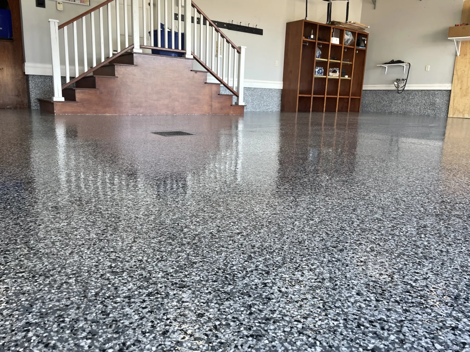 Wide view of glossy grey and black decorative flake flooring in a finished garage interior