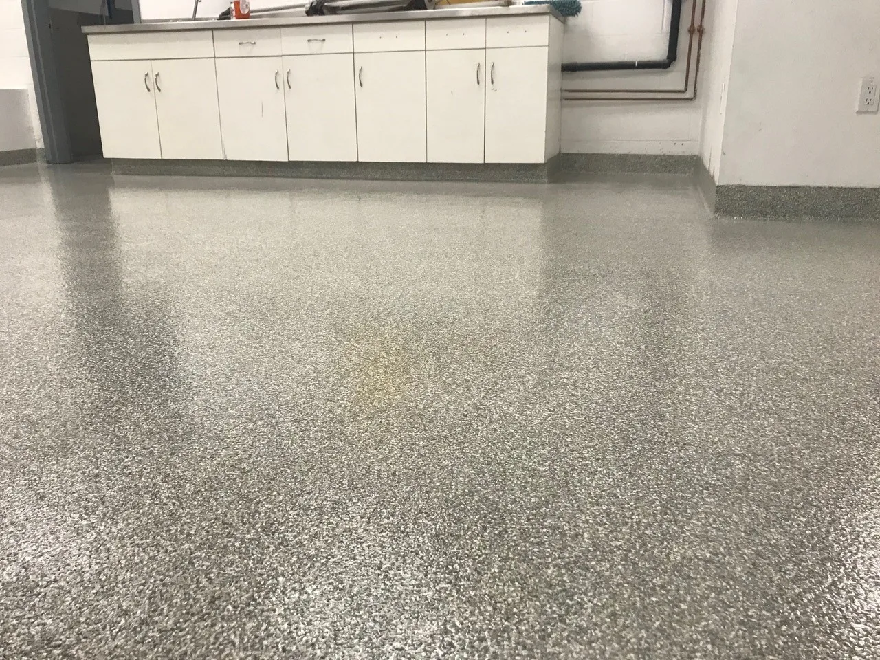 Decorative flake flooring installed across a finished room