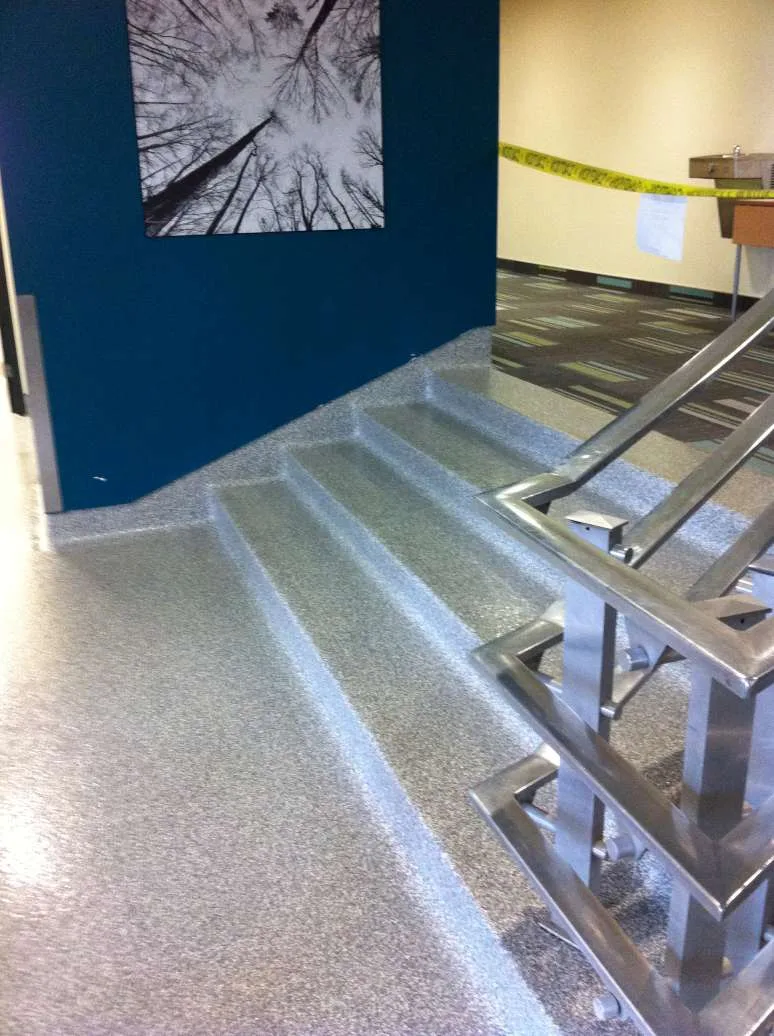 Decorative flake flooring continued over steps and into a cove base