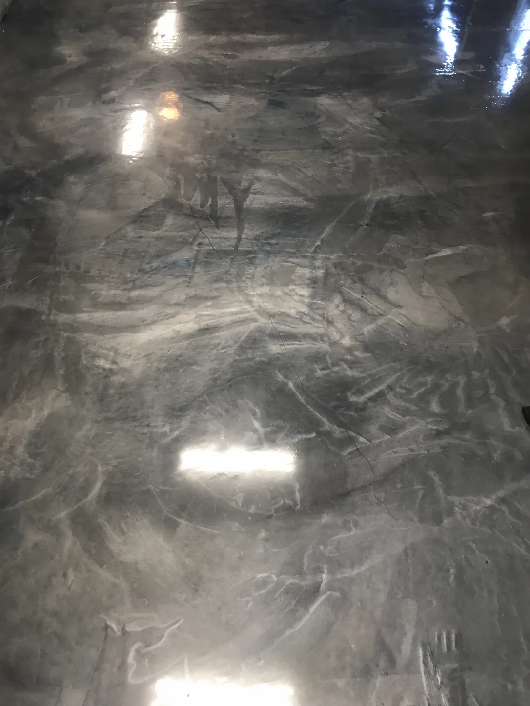 Close view of a glossy charcoal and silver metallic floor with layered movement