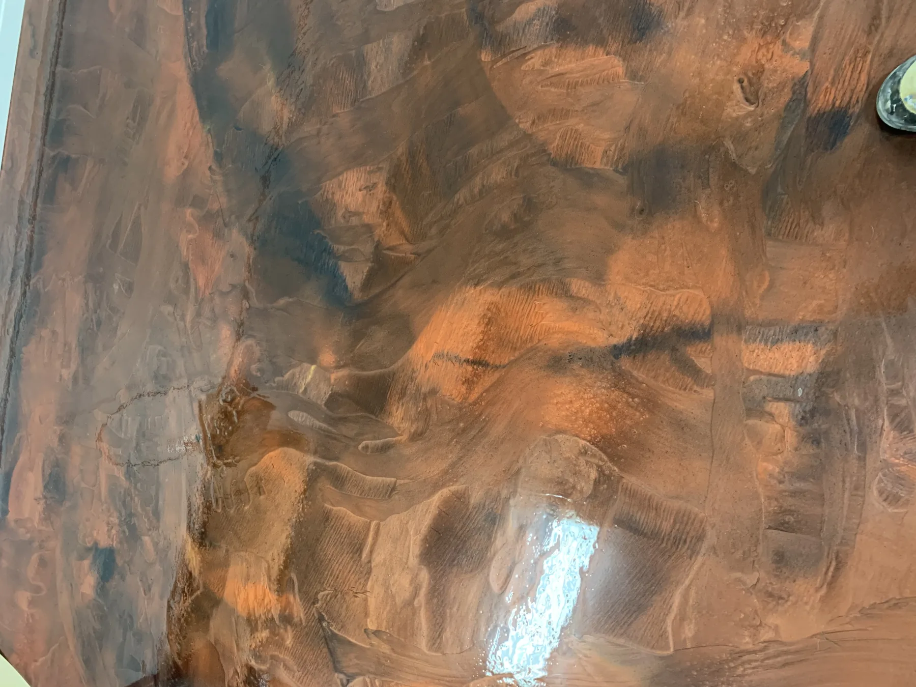 Close view of a copper and charcoal metallic floor with broad hand-applied movement