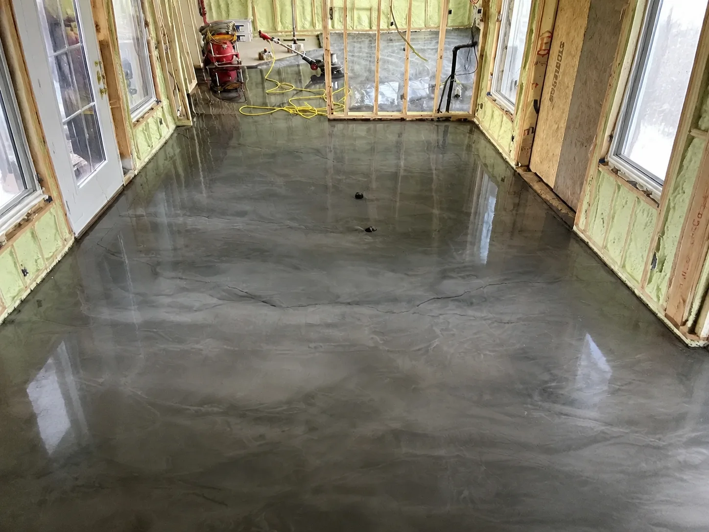 Reflective silver-grey metallic flooring extending through a framed interior corridor