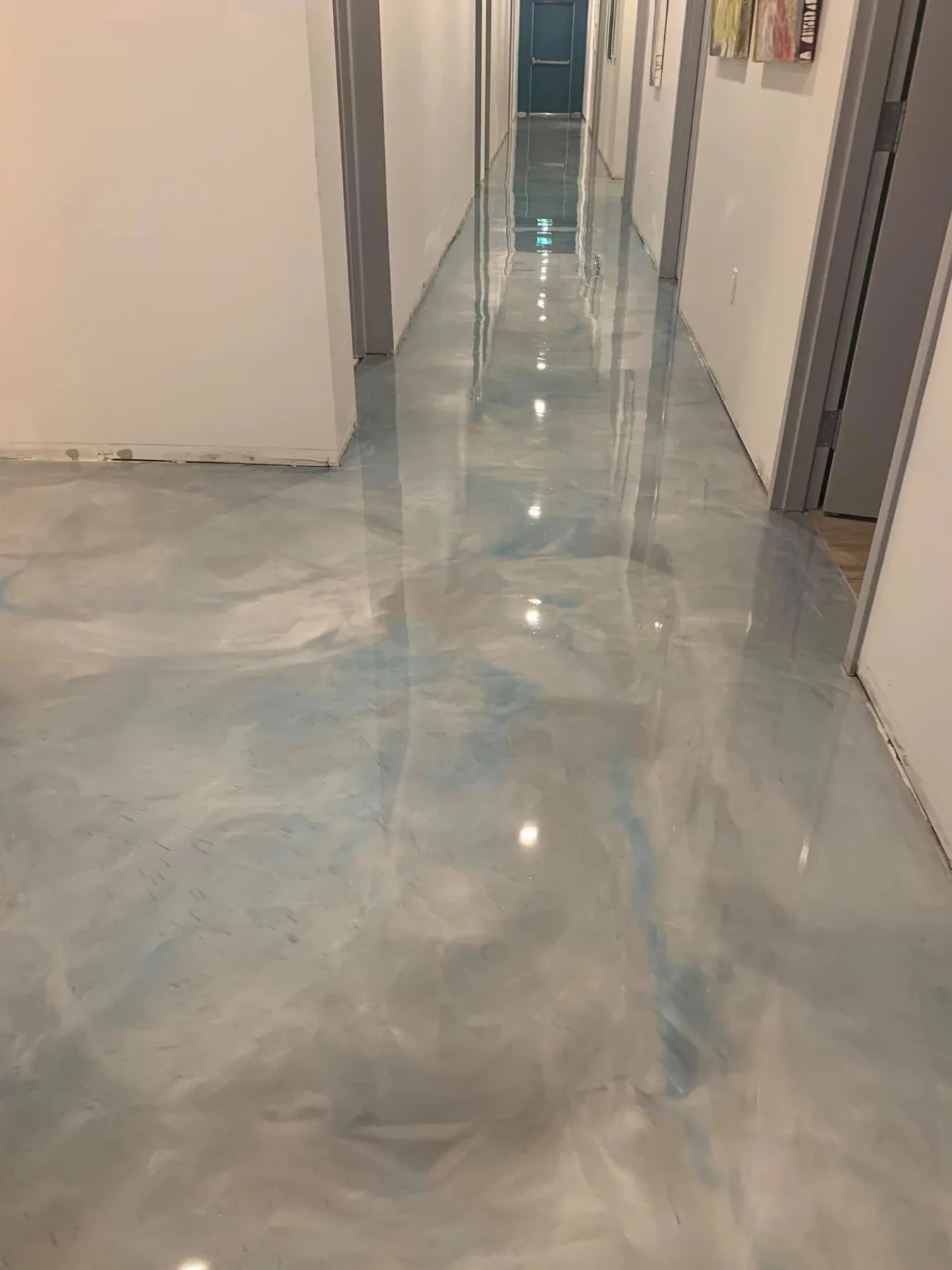 High-gloss silver and pale-blue metallic flooring extending through an interior hallway