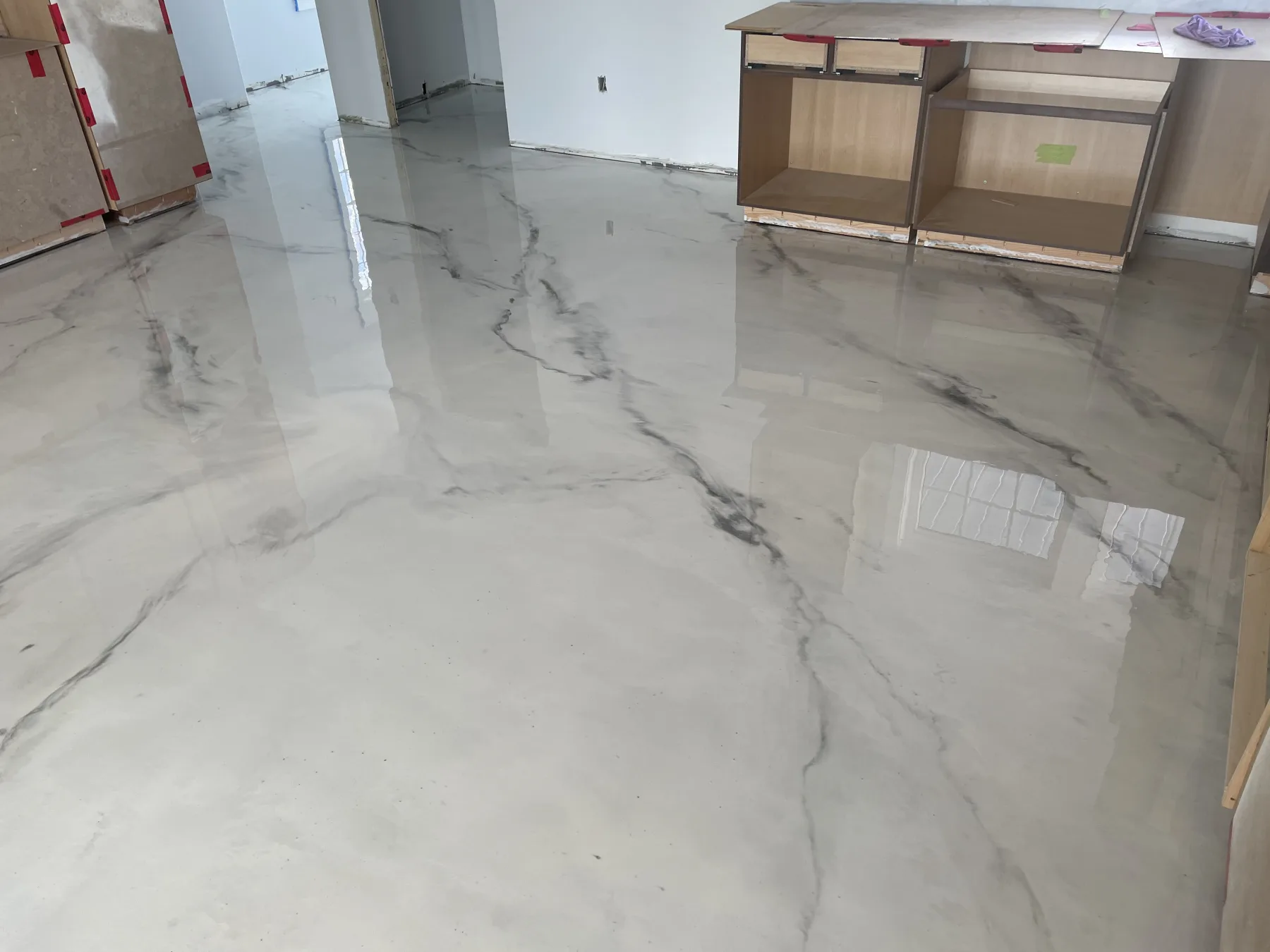 Reflective white and charcoal marble-style metallic floor in a room under construction