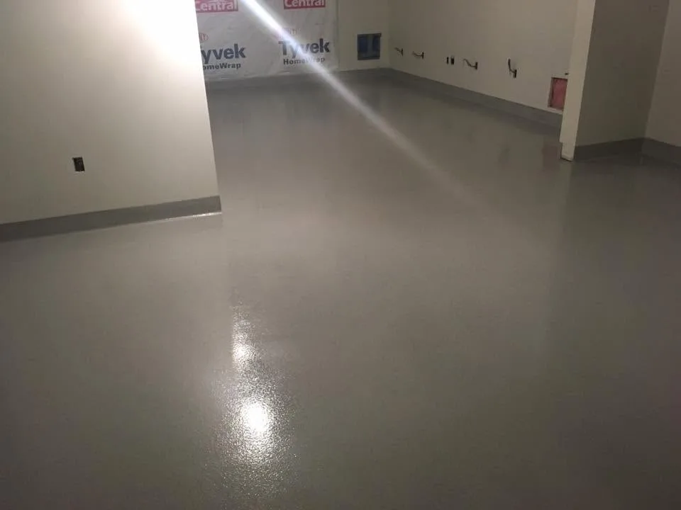 Finished grey seamless floor with integral cove bases in a commercial room