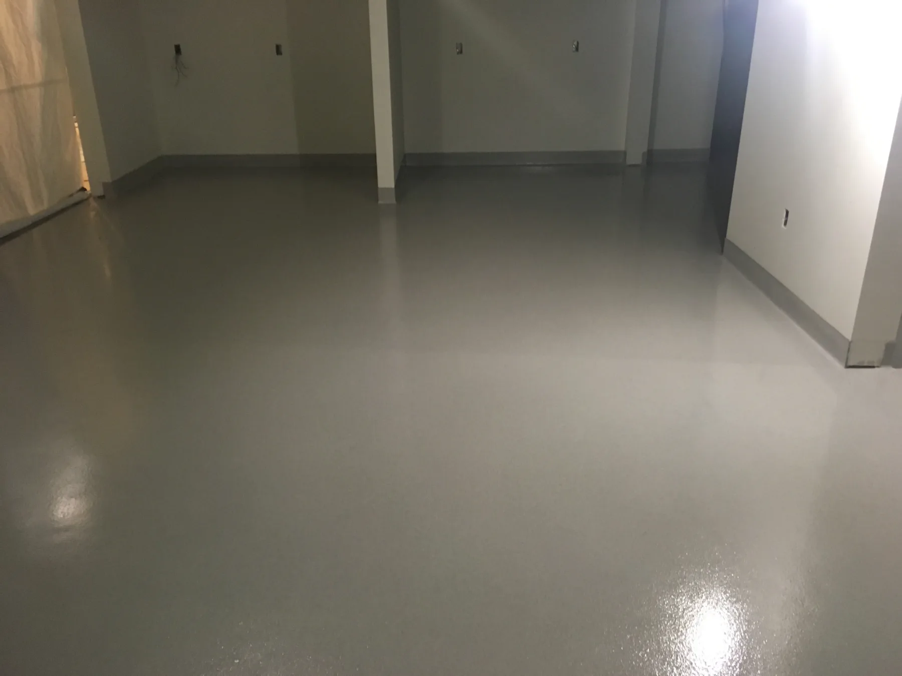 Finished grey seamless epoxy floor across a commercial interior under construction