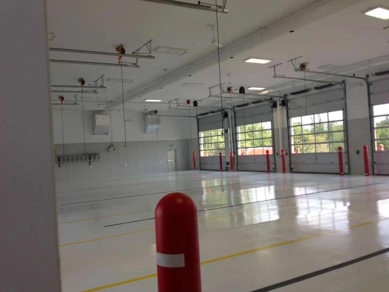 Light-grey epoxy floor in a bright vehicle service facility