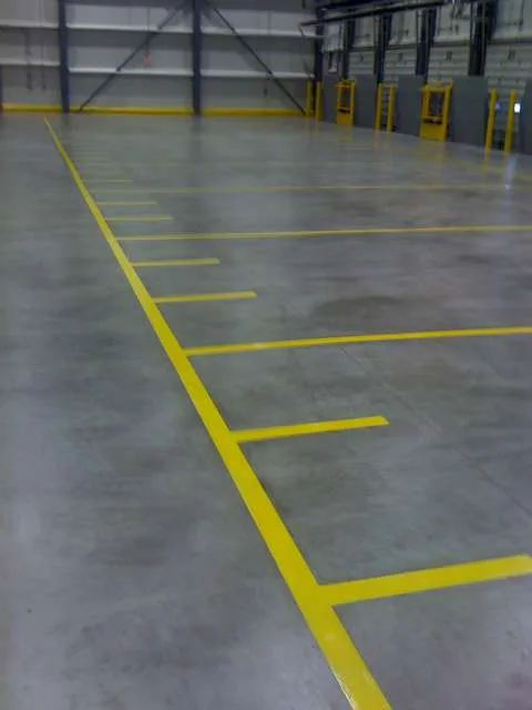 Grey epoxy floor marked with yellow traffic lines