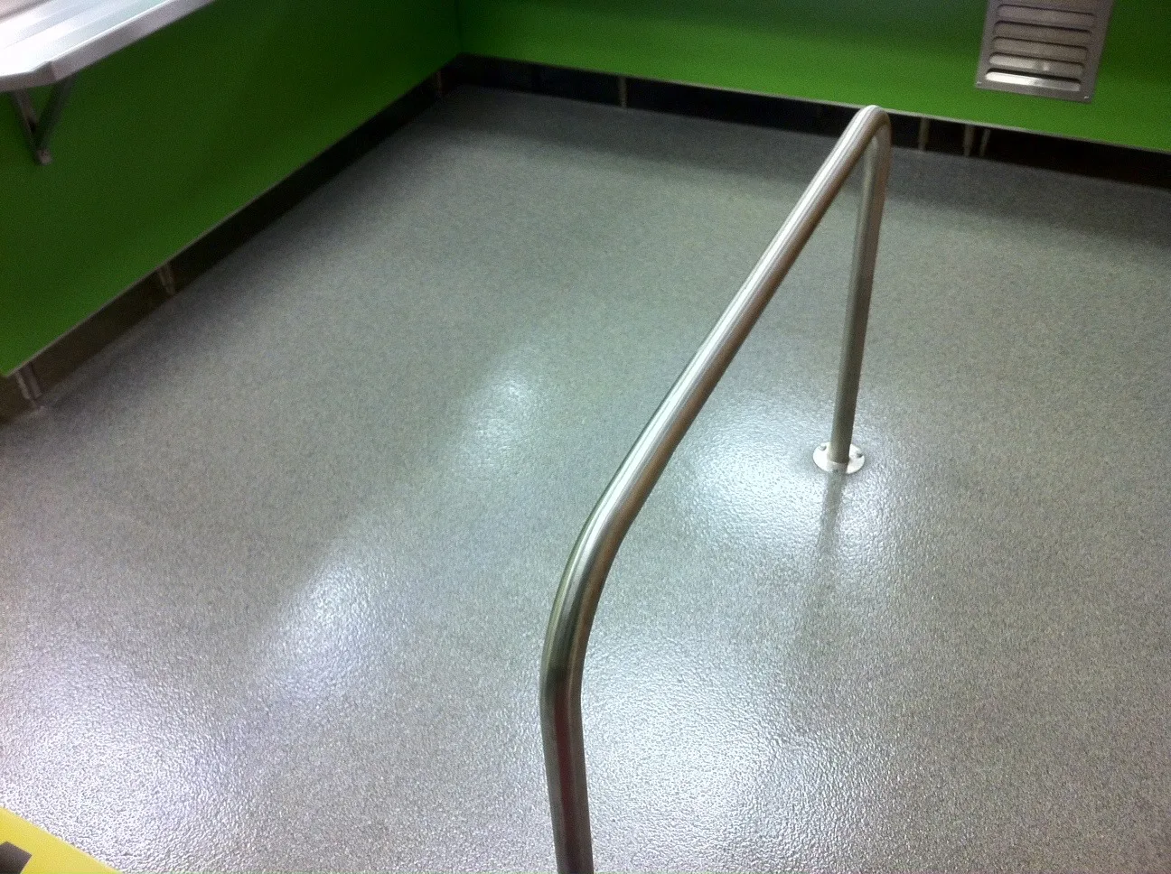 Light-grey decorative quartz floor surrounding stainless-steel equipment