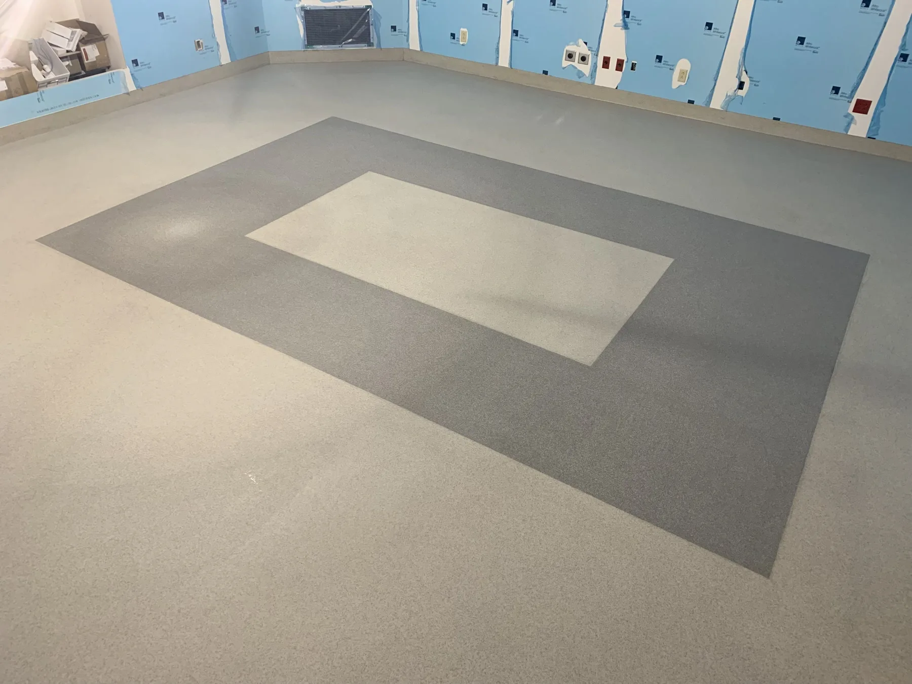 Two-tone light-grey quartz floor with a large geometric border pattern