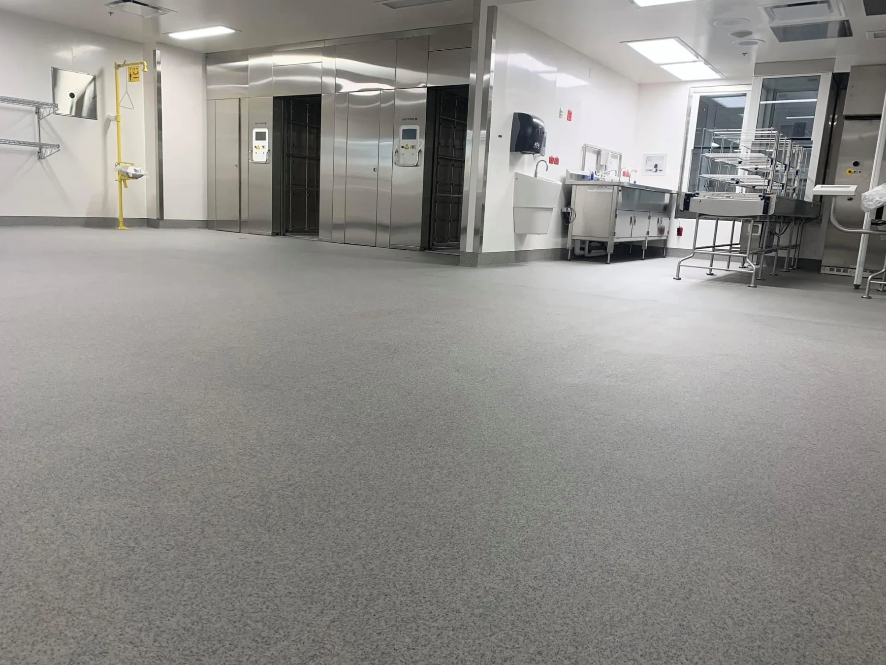 Wide view of light-grey quartz flooring across a hygienic processing room