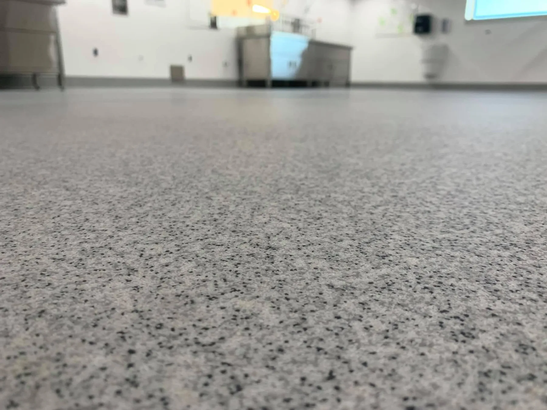 Low-angle close-up of a light-grey quartz floor in a processing area