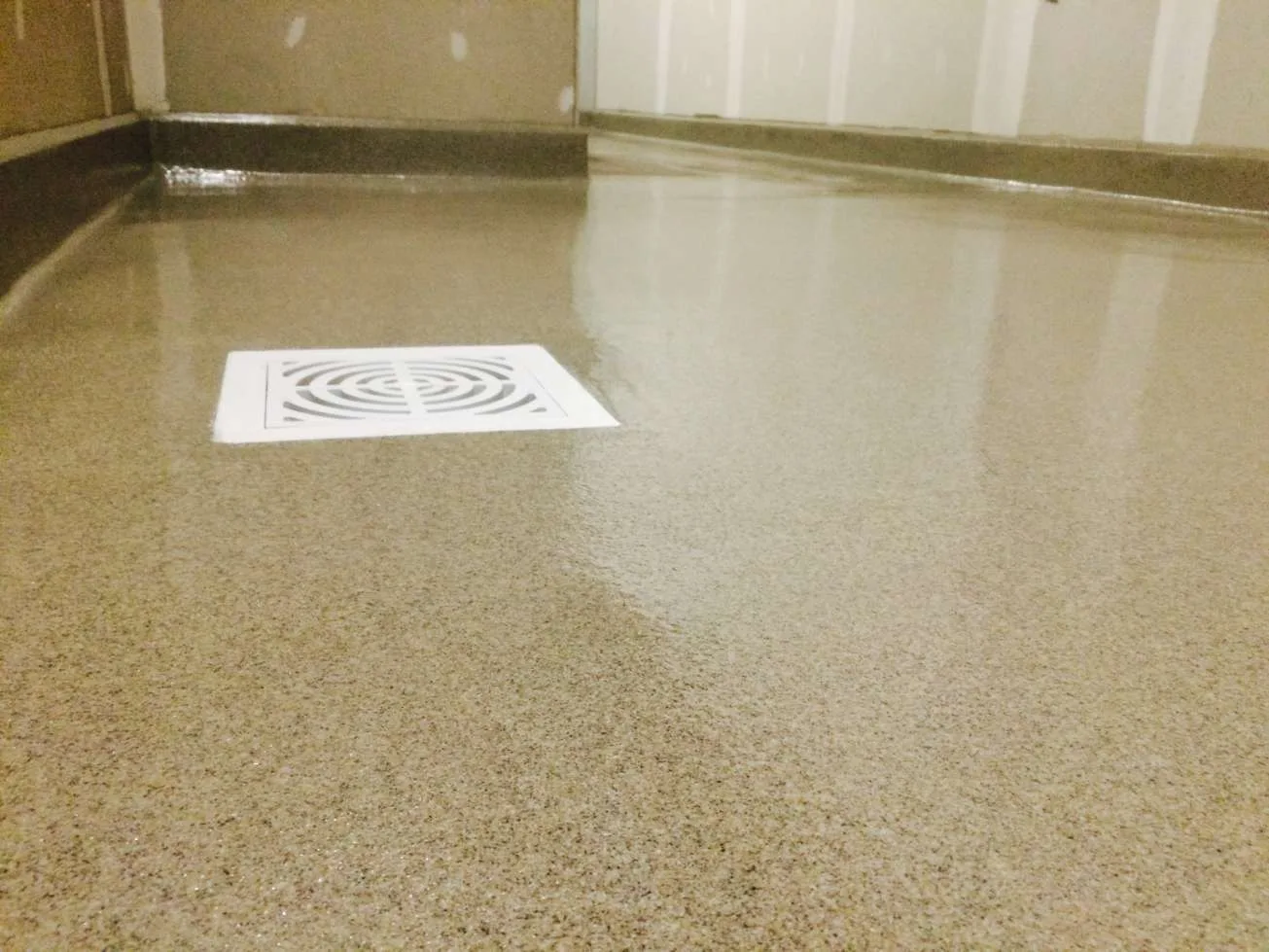 Light decorative quartz floor around a square drain