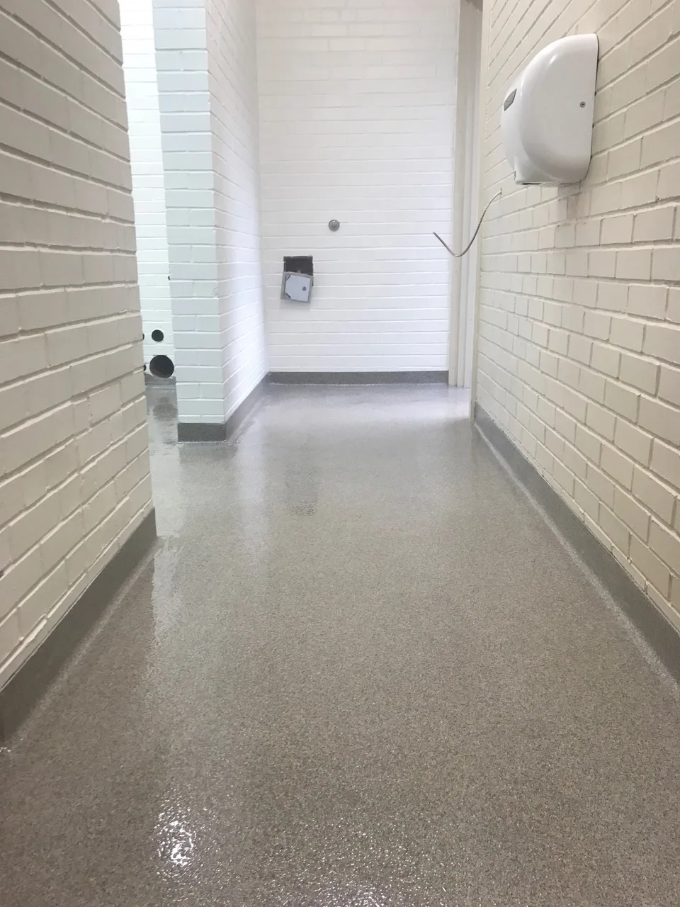 Light troweled quartz floor in a narrow corridor