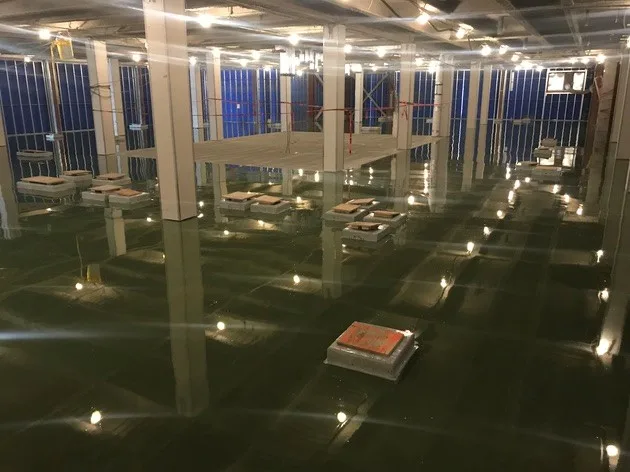Large interior floor covered with a continuous dark waterproofing membrane