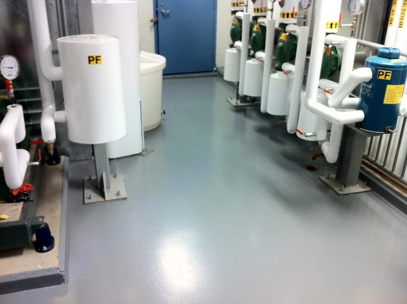 Grey protective membrane flooring around mechanical equipment and pipework