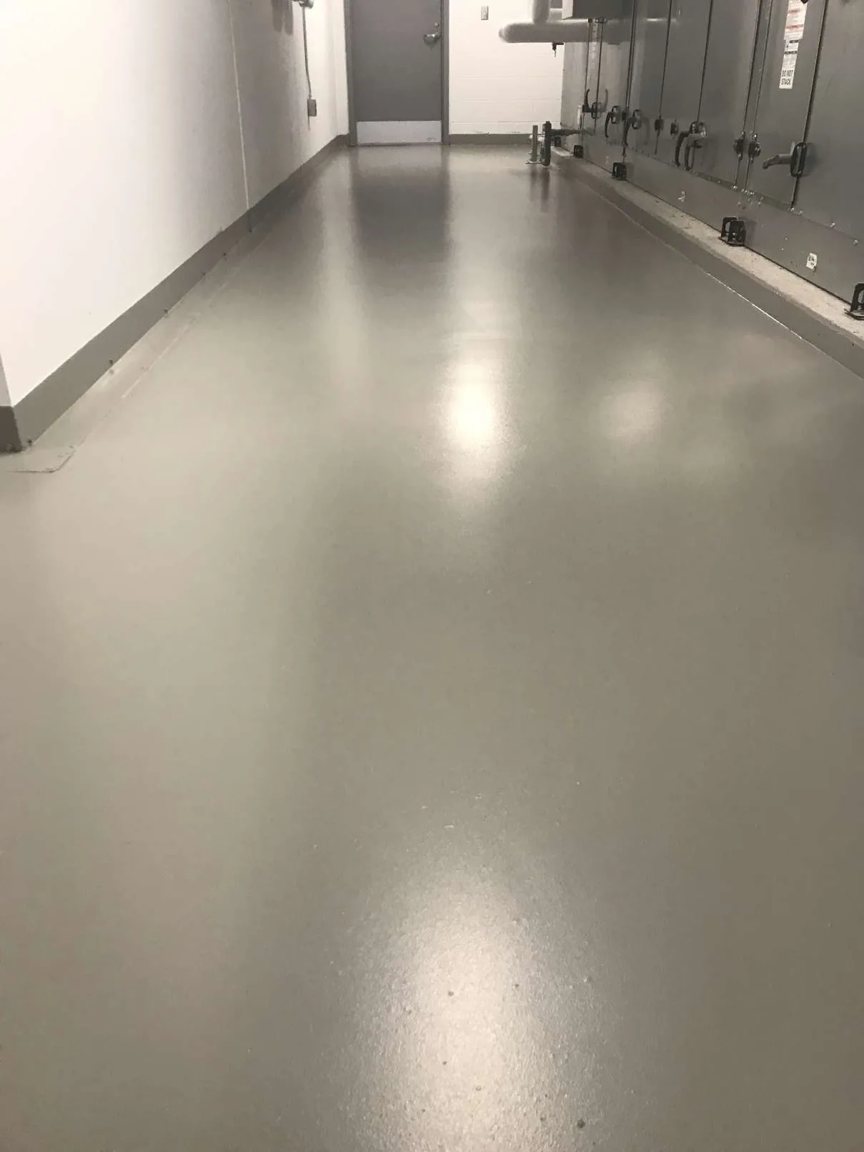 Grey waterproofing membrane in an equipment-room corridor